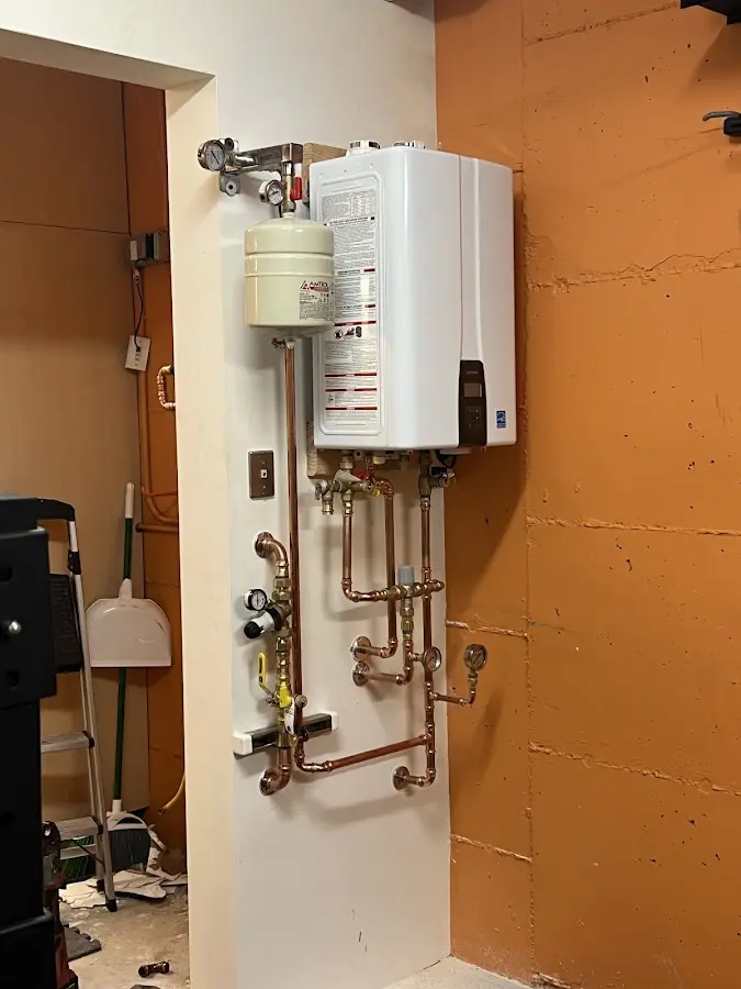 Plumbing technician inspecting water heater connections in Erda